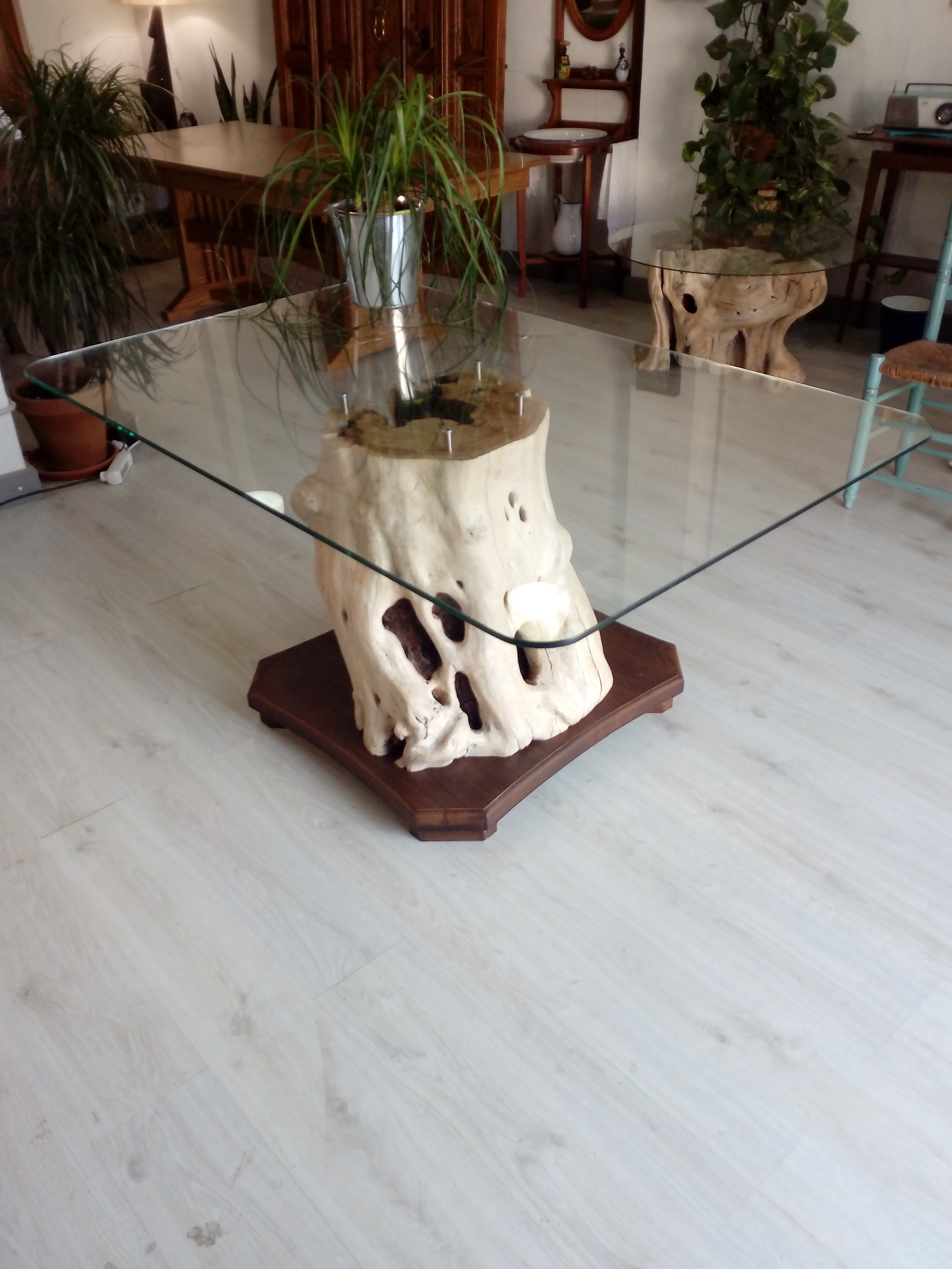 Mesa de olivo con sobre de cristal integrada en un espacio interior