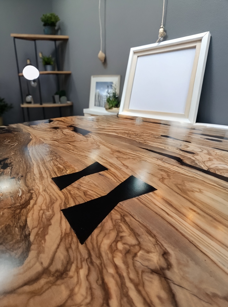 Detalle de uniones de mariposa en mesa de olivo